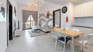 A modern living room with a dining area, a sofa, a coffee table, and a TV.