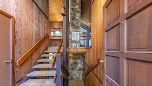 A wooden staircase with stone steps leading to a second floor.