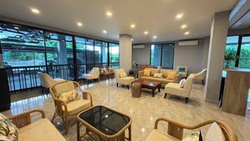 A spacious lobby with a seating area, large windows, and a view of the outdoors.