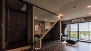 Una sala de estar moderna con una escalera, un ventanal y vistas al exterior.