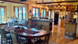 A spacious kitchen with a central island, wooden flooring, and large windows. - Rough & Ready Ranch Retreat- 4 bed/3 bath home w/ gorgeous views (Rough and Ready)