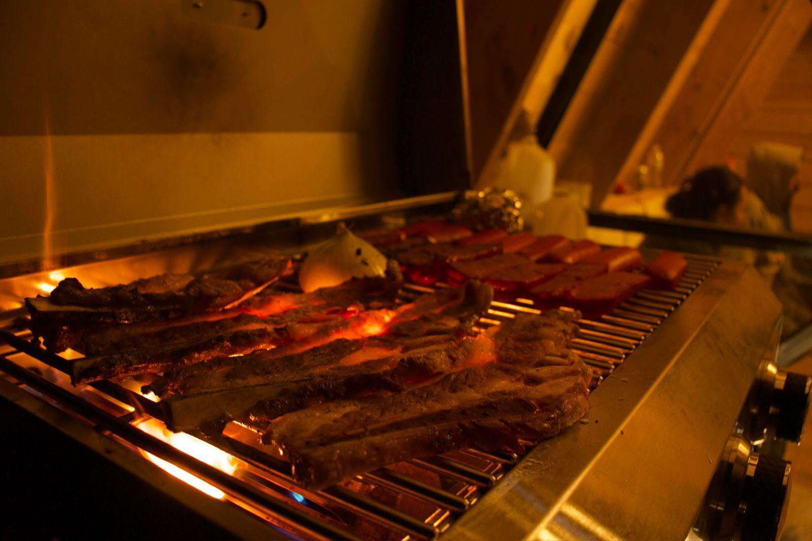 A grill with various meats being cooked.