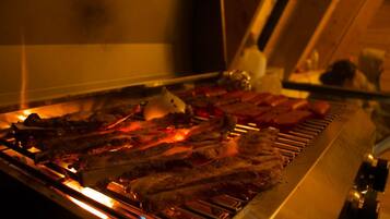 A grill with various meats being cooked.