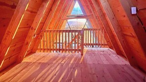 Une chambre mansardée avec des murs en bois et un plafond en pente.