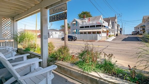 A vacant house with a porch, a sign indicating vacancy, and a phone number.