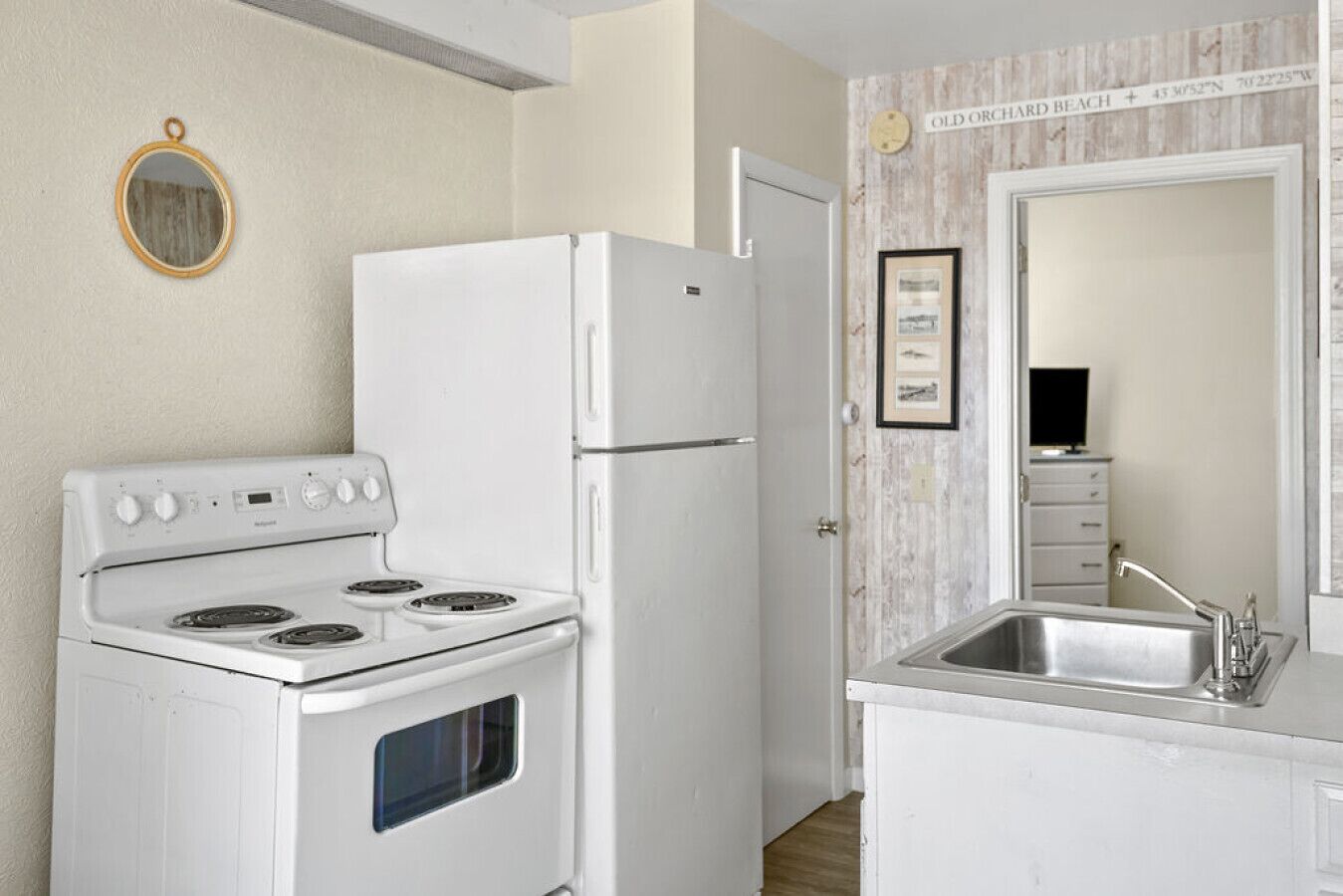 Cocina compacta con estufa, refrigerador y lavaplatos.