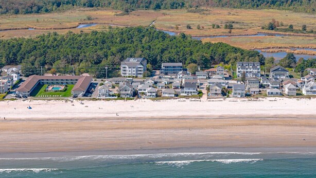 Zona residencial costera con casas, una playa y una masa de agua.