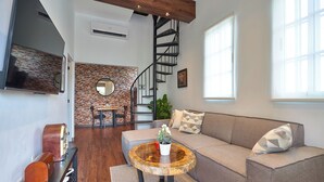 Un salon moderne avec un canapé, une table basse et un escalier en colimaçon.