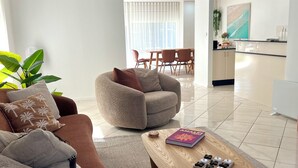 Un soggiorno moderno con un divano marrone, una poltrona beige e un tavolino in legno.