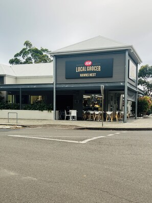 A building with a sign reading 'Local Grocer Hawks Nest.'
