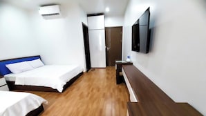 A hotel room with a bed, a desk, a television, and a wardrobe. - Cat Ba Charm Island Hotel (Hai Phong)