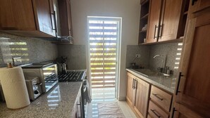 Una cocina moderna con encimeras de granito, armarios de madera y una isla central.