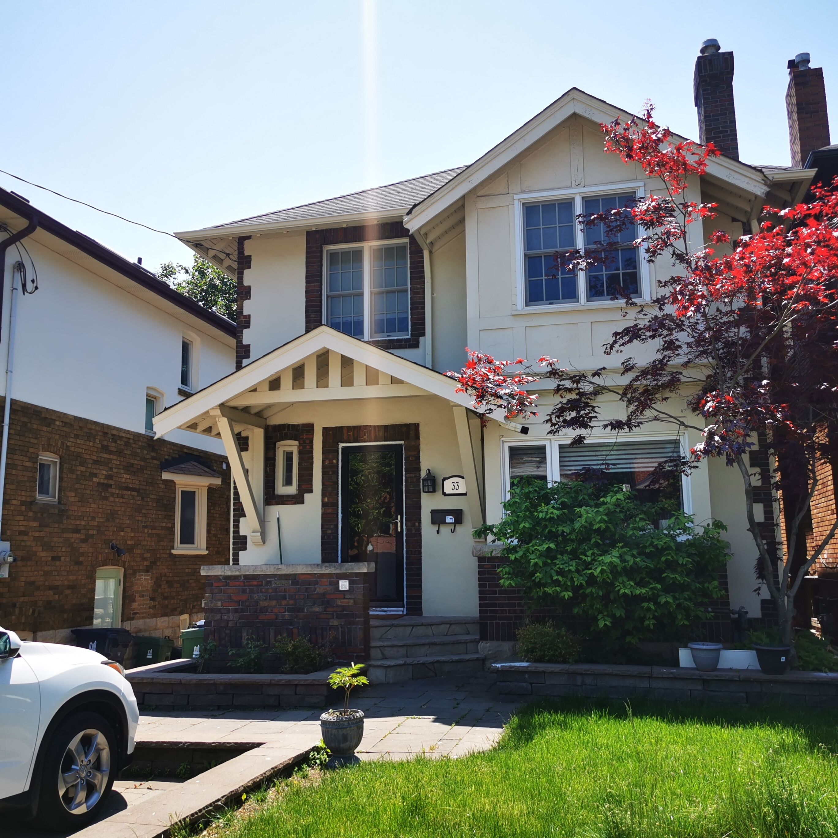 A two-story house with a front porch, a garage, and a driveway.