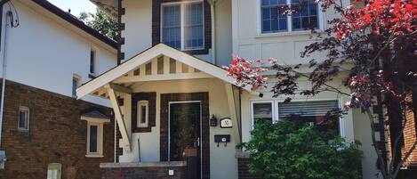 A two-story house with a front porch, a garage, and a driveway.