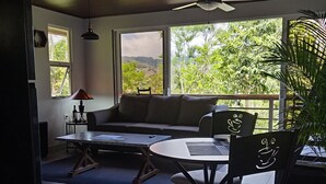 A room with a ceiling fan, a sofa, a dining table with chairs, and a view of greenery outside. - Magnolia Farm Suite
      Giffin House
       Pet friendly (San Isidro de El General)