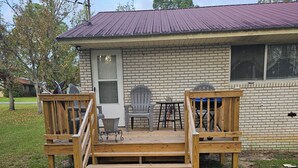 Une maison avec une terrasse en bois, une porte et une fenêtre.