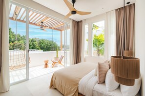 A bedroom with a large bed, a ceiling fan, and a view of greenery outside. - Villa Tomar El Sol by Alfred in Bali (Pecatu)