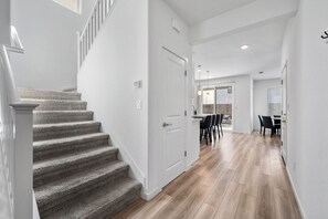 Un interno moderno con una scala, un'area pranzo e una cucina.