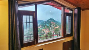 Ein Zimmer mit großem Fenster und Blick auf eine Berglandschaft.