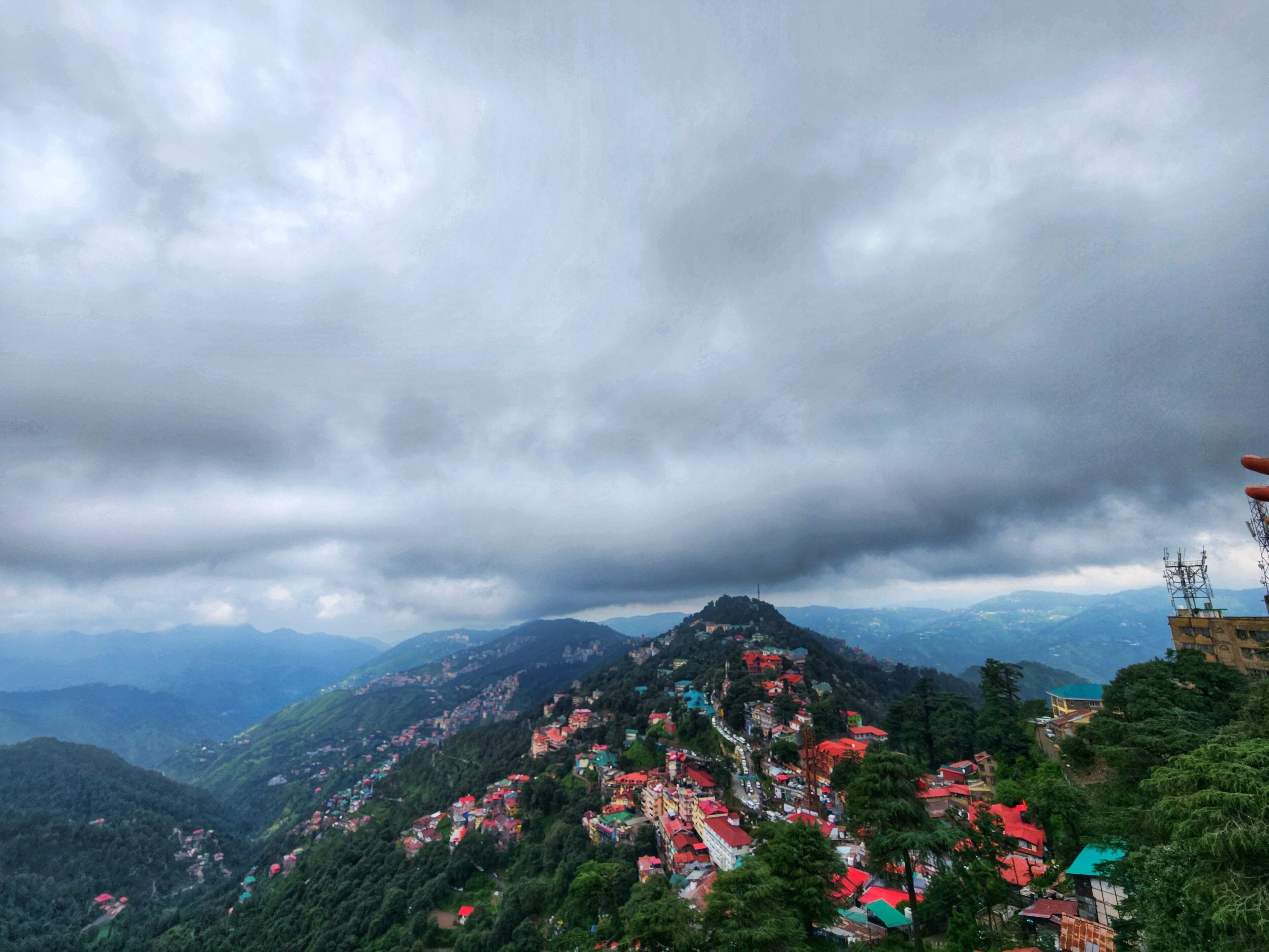 A mountainous village with traditional houses and a prominent hilltop structure.