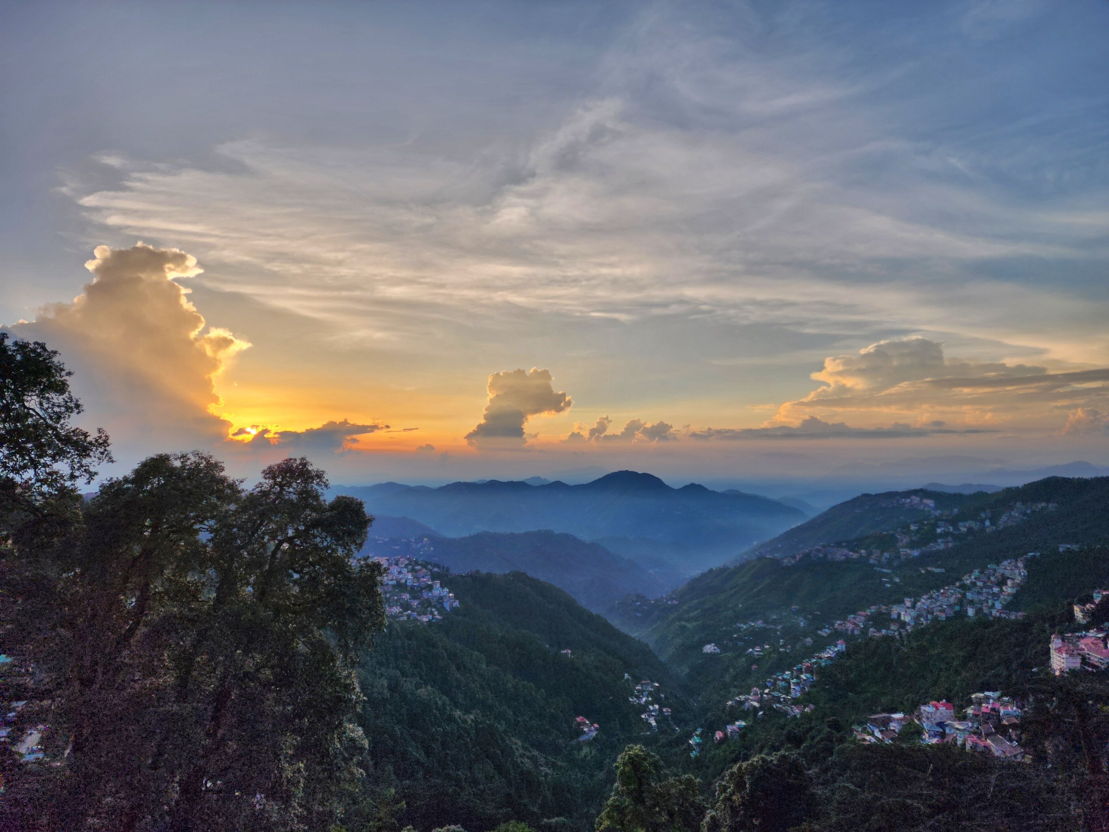 Paisagem montanhosa com vale e edifícios dispersos.