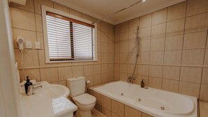 Une salle de bain avec des toilettes, un lavabo et une baignoire.