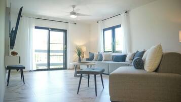 Un salon avec un canapé, une table basse et un ventilateur de plafond.