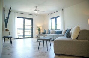 A living room with a sofa, a coffee table, and a ceiling fan.