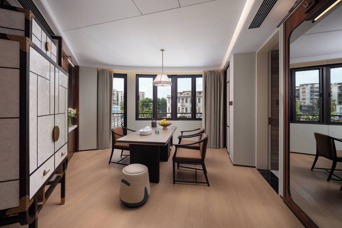Un comedor moderno con una mesa, sillas y un jarrón decorativo.