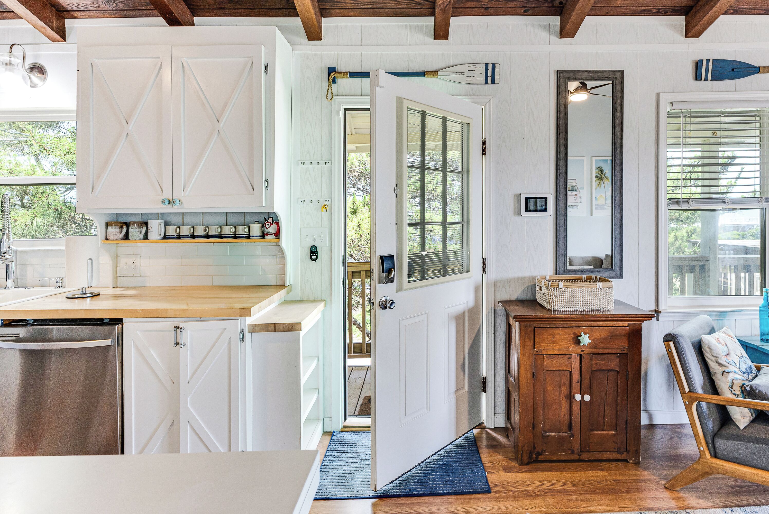 A kitchen with white cabinetry, a wooden countertop, and a built-in dishwasher.