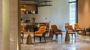 Ein modernes Interieur mit Ledersesseln, einer Bar und einem großen Fenster.
