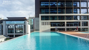 Un hotel moderno con piscina, ventanas amplias y un edificio de varios pisos.