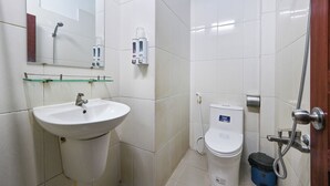 A bathroom with a white sink, a mirror, a toilet, and a shower. - Hoang Phung Hotel - Tan Son Nhat Airport (Ho Chi Minh City)