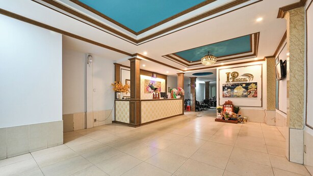 A hotel reception area with a reception desk, a chandelier, and a wall with a sign that reads "HOTEL". - Hoang Phung Hotel - Tan Son Nhat Airport (Ho Chi Minh City)