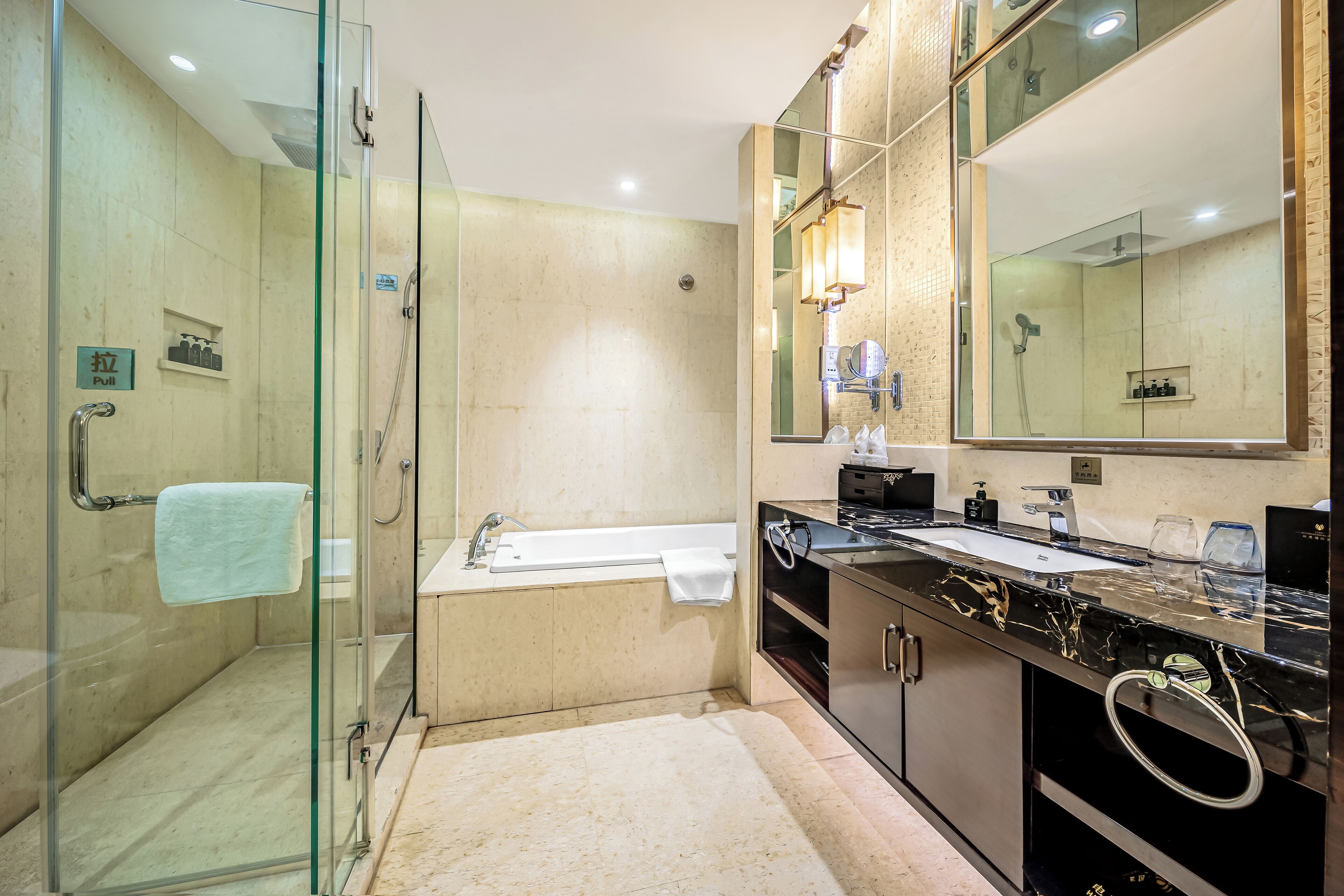 A modern bathroom with a glass-enclosed shower, a separate bathtub, and a vanity with a large mirror.