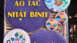 A display of traditional Vietnamese hats and a sign with the text "BÁN & CHO THUẾ" and "AO TÁC NHẬT BÌNH". - Moc Truly Hue Homestay (Hue)
