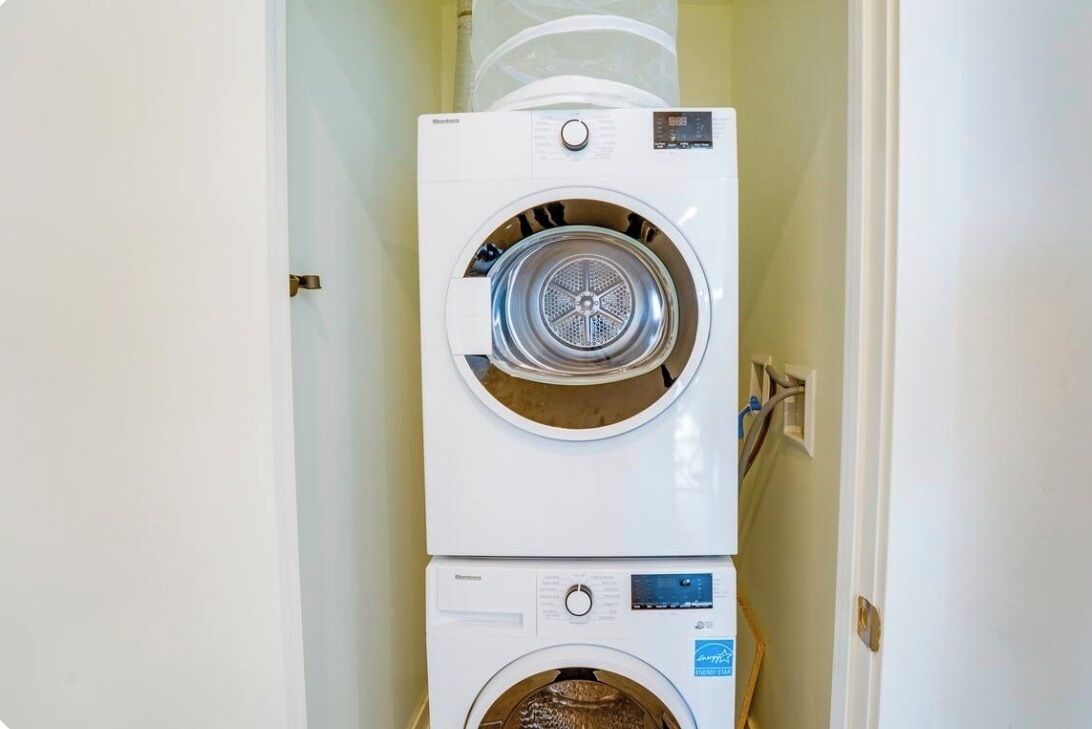 A stacked washer and dryer unit in a laundry room.