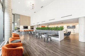 Un intérieur moderne comprenant un espace salon, un comptoir d’accueil et un écran de télévision.