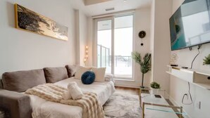 Ein modernes Schlafzimmer mit einem Bett, einem Fernseher und einem Fenster.