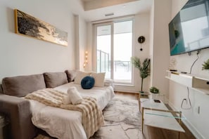Une chambre moderne avec un lit, une télévision et une fenêtre.