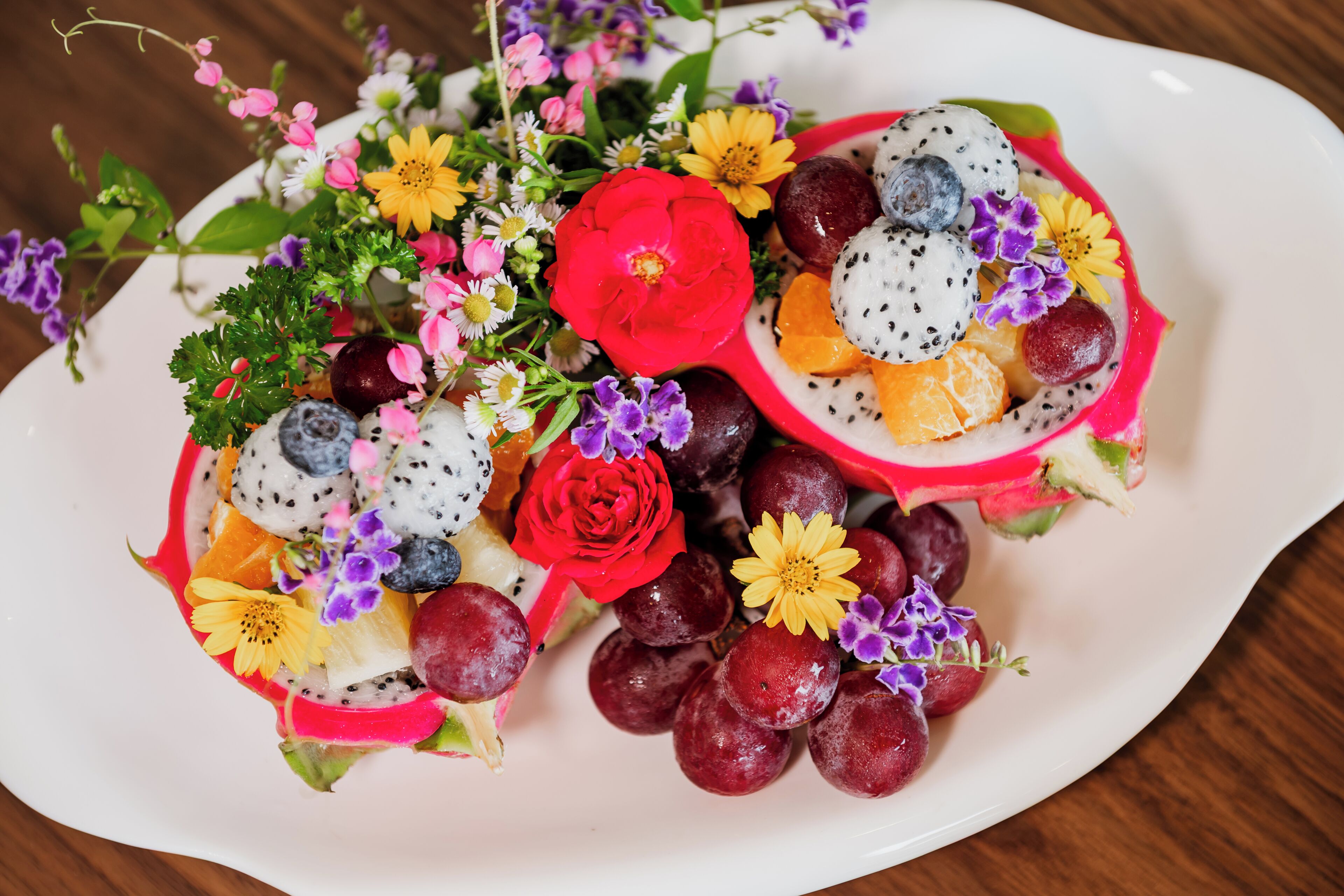 Un assortiment de fruits frais, présenté sur un plateau et agrémenté de fleurs.