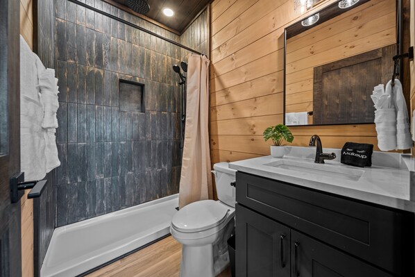 Un bagno moderno con doccia, servizi igienici, lavandino e mobile lavabo.