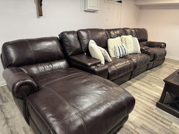 A brown leather sectional sofa with a chaise, two side tables, and decorative pillows. - Cozy Family Getaway near Notre Dame on a Quiet Street (South Bend)