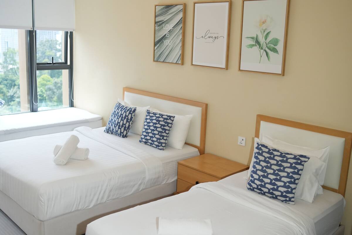 Een hotelkamer met twee bedden, een raam en wanddecoratie.