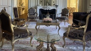 A grand room with ornate furniture, a fireplace, and elaborate wall decorations.