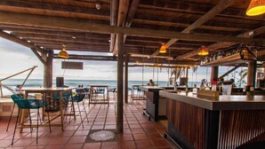 Ein Restaurant direkt am Strand mit Außenbereich, einer Bar und Blick auf das Meer.