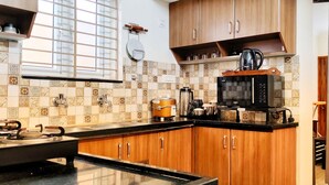Una cocina con armarios de madera, una estufa a gas, un microondas y un hervidor.
