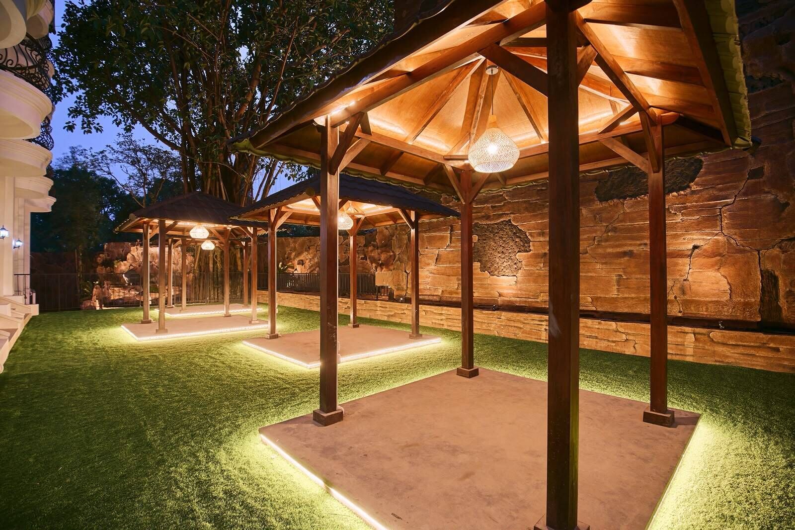 An outdoor patio area with wooden pergolas and artificial grass.