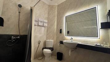 A modern bathroom with a shower, toilet, and sink.