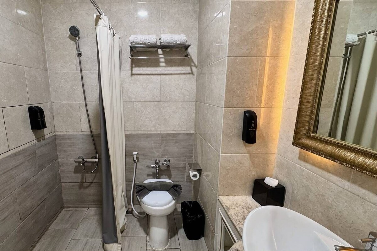 Un baño pequeño con inodoro, bidé y zona de ducha.
